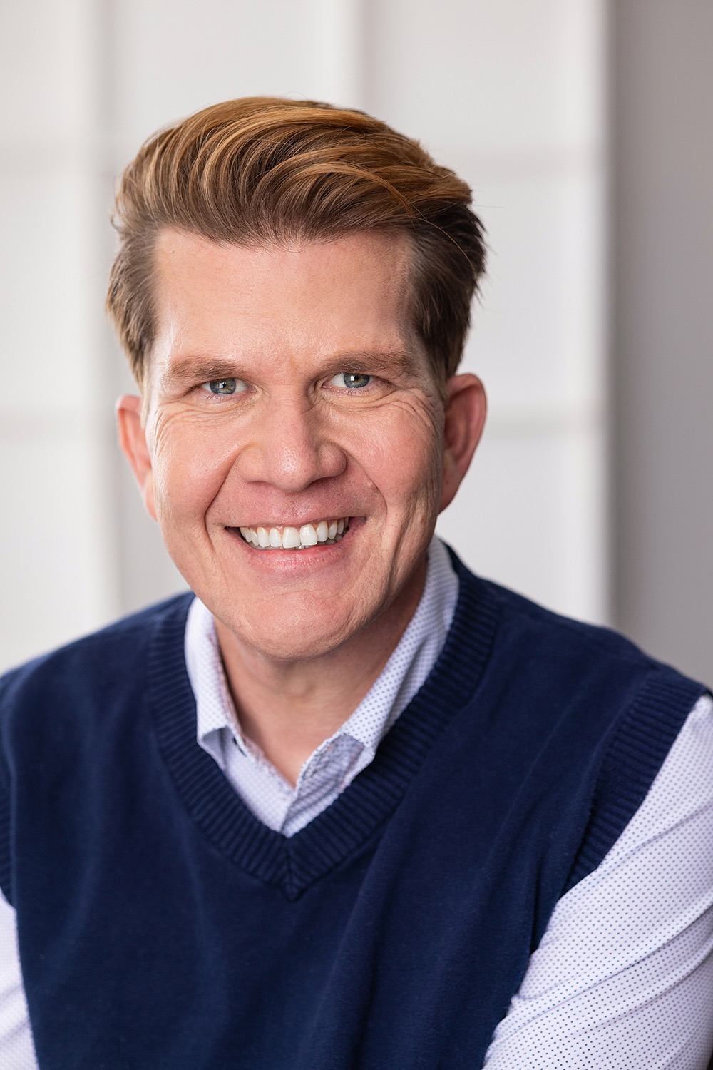 Jonas Åsberg commercial headshot in blue shirt.